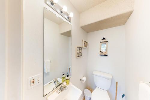 La salle de bains est pourvue de toilettes blanches et d'un miroir. dans l'établissement Dolphin #20, à South Padre Island