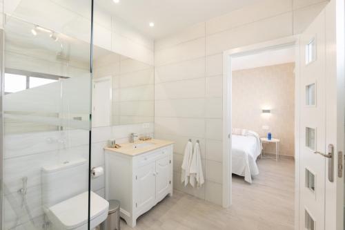 y baño blanco con lavabo y ducha. en Villa Sea Breeze Jarea, en Playa Blanca