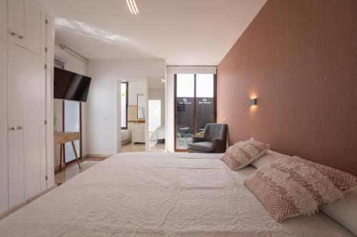 a bedroom with a large bed and a chair at Villa Sea Breeze Jarea in Playa Blanca