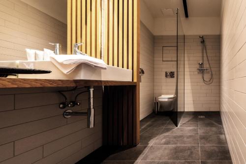 a bathroom with a sink and a shower and a toilet at Blackhome Graz I contactless check-in in Graz