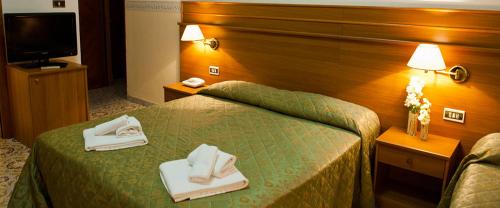 a hotel room with a bed with towels on it at Hotel Capys in Capua