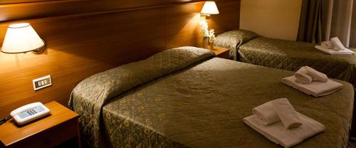 um quarto de hotel com duas camas com toalhas em Hotel Capys em Capua