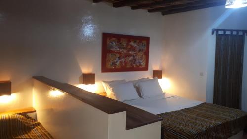 1 dormitorio con 1 cama con luces en la pared en Esperanto Lodge en Kafountine