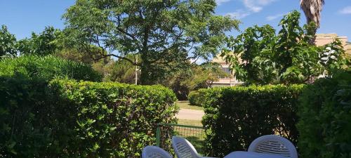 a person sitting on a bench in front of some bushes at SOLEIL34 in Palavas-les-Flots