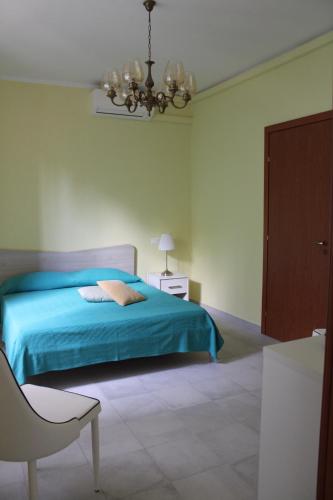 a bedroom with a blue bed and a chandelier at B&B Murichessa(Il Gelso) in Orosei