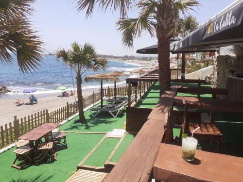 a row of tables and chairs on the beach at Hotel Patricia in Torreguadiaro