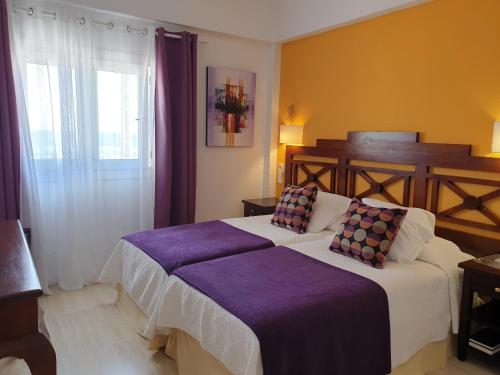 a hotel room with two beds and a window at Hotel Boutique Las Arenas in Es Cana