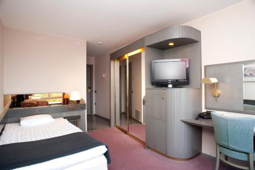 a hotel room with a bed and a flat screen tv at Memory Hotel in Stockholm