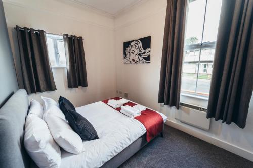 um pequeno quarto com uma cama e uma janela em The Stay Company, Dalby House em Derby