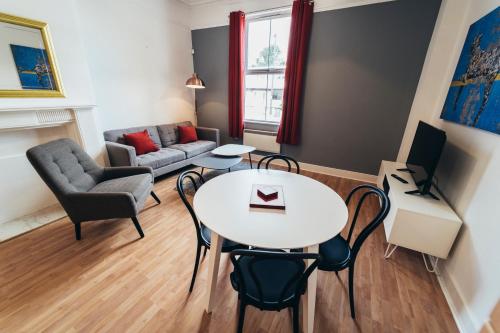 a living room with a table and chairs and a couch at The Stay Company, Dalby House in Derby