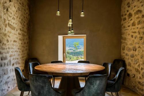 a dining room with a wooden table and chairs at Torre del Marqués Hotel Spa & Winery - Small Luxury Hotels in Monroyo