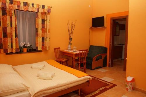 a small room with a bed and a table with a dining room at Villa Victoria Penzion in Liptovský Ján