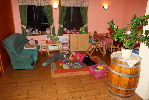 a boy and a girl playing in a living room at Villa Victoria Penzion in Liptovský Ján