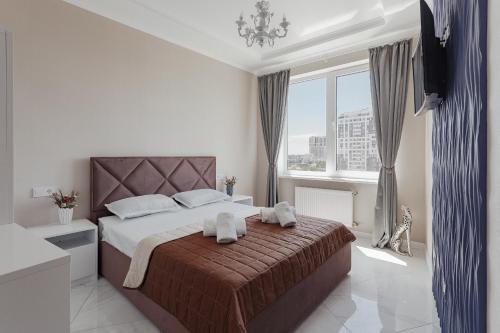 1 dormitorio con 1 cama grande y toallas. en Vip Apartments Arcadia, en Odessa