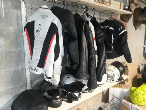 a bunch of jackets and helmets on a shelf at L'Entre 2 Cols in Saint-Martin-sur-le-Chambre