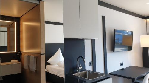 a bathroom with a sink and a bed at LE Hotel by WMM Hotels in Leipzig