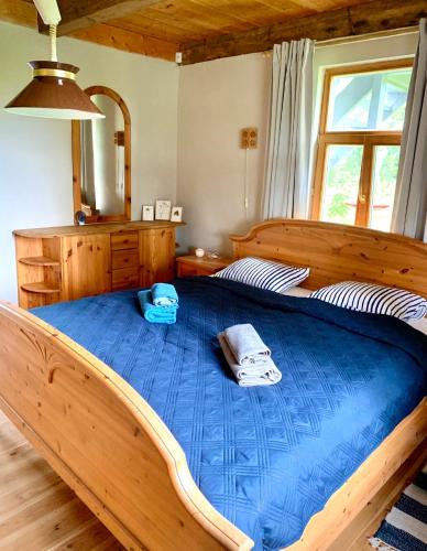 a bedroom with a large wooden bed with blue sheets at Lejnieki Apartment 2 in Pape