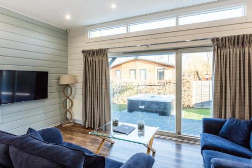 a living room with a couch and a tv and a table at Roydon Marina Village Lodges in Roydon