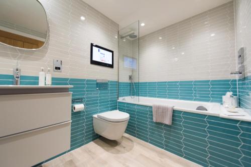 a bathroom with a toilet and a tub and a sink at Juliot 5 Star Gold Award Luxury Cottage in St Ives