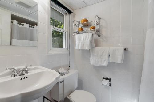 a bathroom with a toilet, sink, and mirror at Towne Lyne Motel in Ogunquit