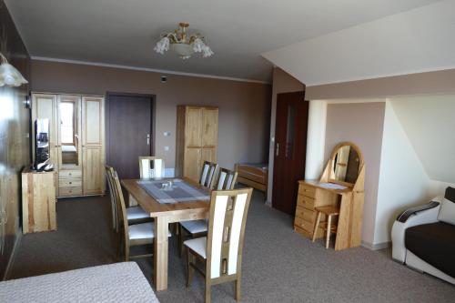 a room with a dining room table and chairs at Dwór Bogdałów in Koniaków