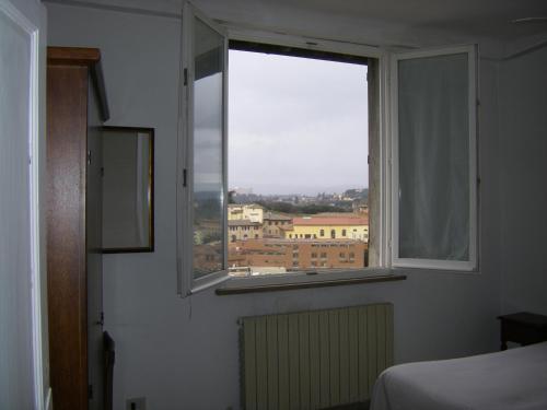 a bedroom with a window with a view of a city at Albergo Cannon d'Oro in Siena