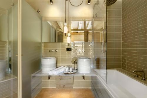 a bathroom with a tub and a sink and a shower at Torre del Marqués Hotel Spa & Winery - Small Luxury Hotels in Monroyo