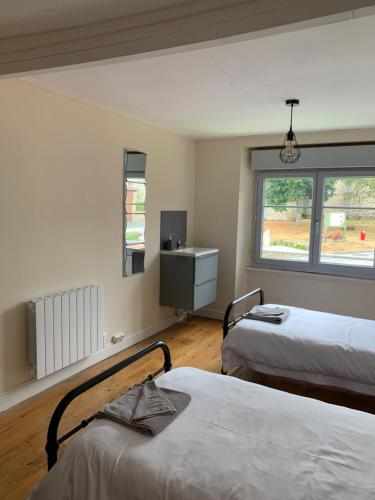 a room with two beds and a sink in it at Doxie Cottage in Saint-Chabrais