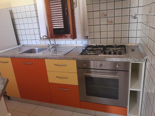 a kitchen with a stove and a sink at Casa Barbara - servizi inclusi - services included in Capoliveri