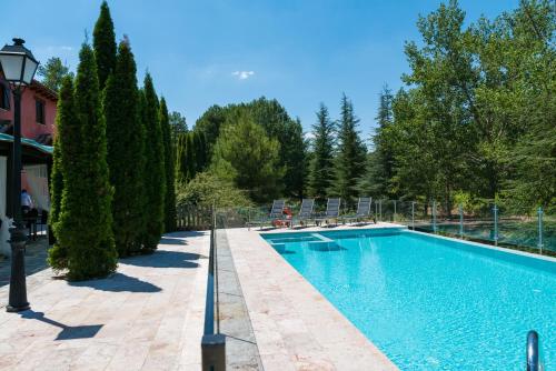 una piscina en un patio con árboles en La Casita de Cabrejas, en Jábaga