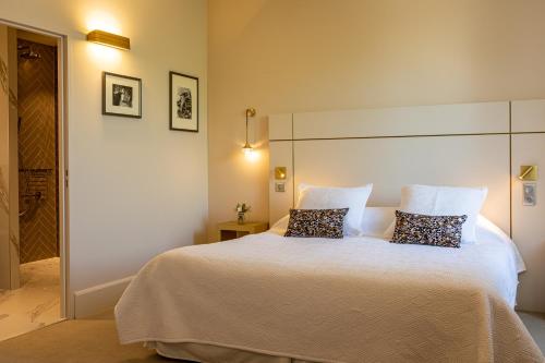 a bedroom with a large white bed with two pillows at Olivier Leflaive Hôtel Restaurants in Puligny-Montrachet