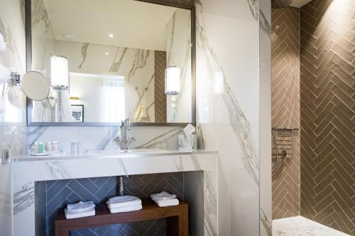 
a bathroom with a sink and a mirror at Olivier Leflaive Hôtel Restaurant in Puligny-Montrachet
