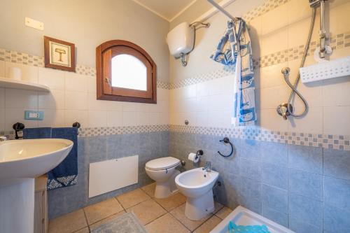 un baño con inodoro y lavabo en Casa Vacanza de Dinu, en SantʼAnna Arresi