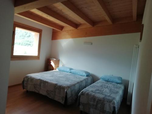 a bedroom with two beds in a room with a window at Agriturismo Summus Lacus in Riva