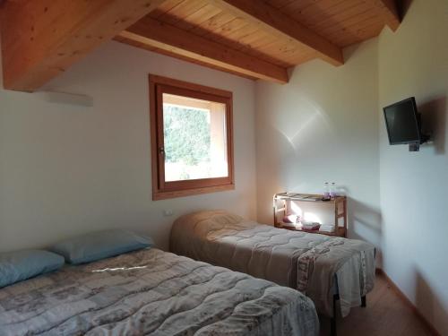 a bedroom with two beds and a window at Agriturismo Summus Lacus in Riva
