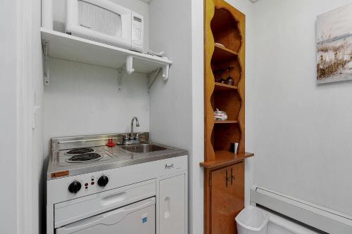 a small kitchen with a stove and a microwave at Towne Lyne Motel in Ogunquit