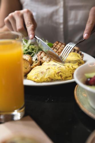 a person eating a plate of food with a fork and knife at Gild Hall, A Thompson Hotel, by Hyatt in New York