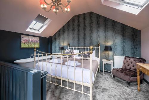 a bedroom with a bed and a tub and a chair at The Westleton Crown in Westleton