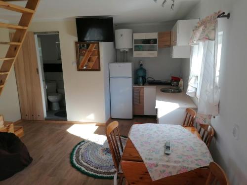 a kitchen and dining room with a table and a refrigerator at Noclegi Pod Dachem pokoje gościnne domek letniskowy na wynajem agroturystyka wakacje in Sajzy