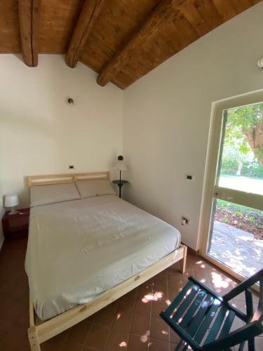 a bedroom with a bed and a chair and a window at Karrua House in Modica