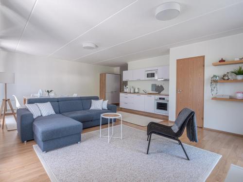 a living room with a blue couch and a chair at Pärnu Ranna Residents in Pärnu