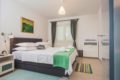 1 dormitorio con 1 cama con un gato sobre una mesa en Mandalina HR Luxury Villa with Private Pool, Tennis Court and Boccie Alley, en Donji Proložac