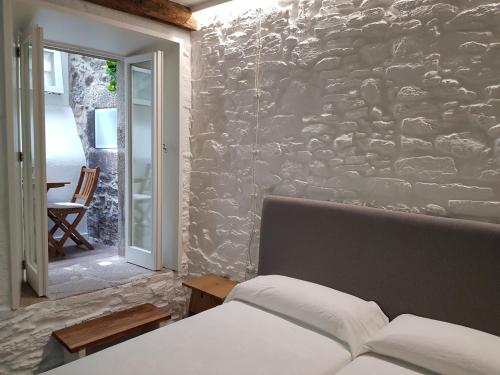 - une chambre avec un mur en pierre et un lit dans l'établissement Pensión con Encanto San Martiño Pinario, à Saint-Jacques-de-Compostelle