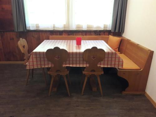 a table with two chairs and a red cup on it at Ferien in der Bergwelt von Adelboden in Adelboden