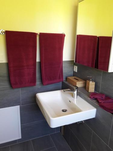 a bathroom with a white sink and red towels at Ferien in der Bergwelt von Adelboden in Adelboden