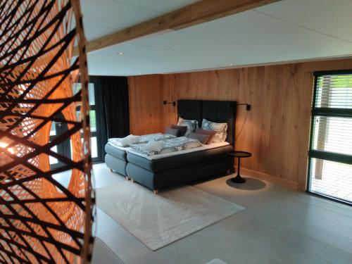 a bedroom with a bed in a room with wooden walls at B&B Loft-13 in Opende