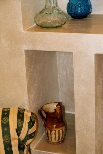 a shelf with a vase and a vase on it at Rooms Dimora Arco - Affitti Brevi Italia in Monte SantʼAngelo