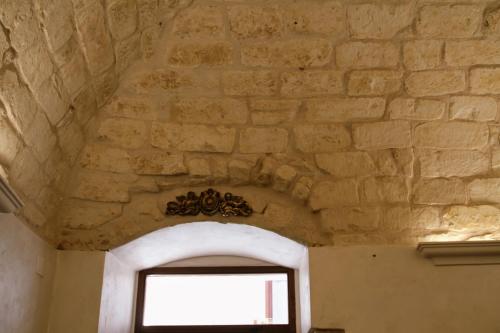 a room with a stone wall and a window at Rooms Dimora Arco - Affitti Brevi Italia in Monte SantʼAngelo