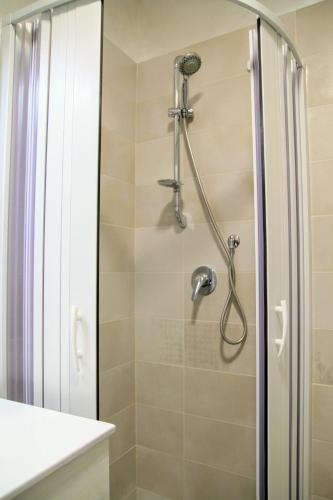 a shower with a shower head in a bathroom at Rooms Dimora Arco - Affitti Brevi Italia in Monte SantʼAngelo