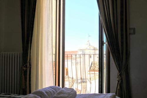 a bedroom with a window with a view of a balcony at Rooms Dimora Arco - Affitti Brevi Italia in Monte SantʼAngelo